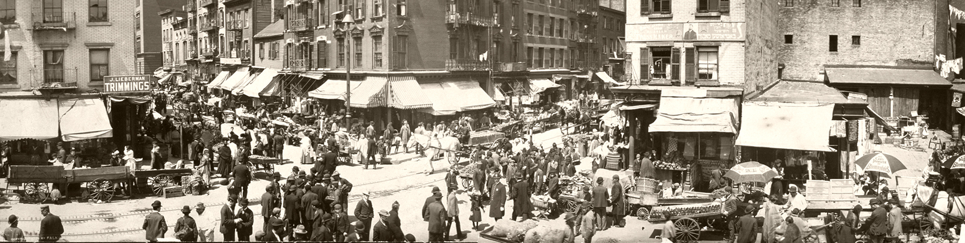 Crowded street market with pushcarts and awnings, sepia panorama — historic image