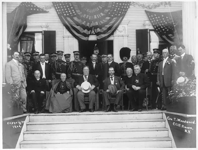 President Taft, Governor [Charles] Hughes, Cardinal Gibbons and other state and church dignitaries [posed outside at top of steps] at the Catholic Summer School of America, Cliff Haven, N.Y.