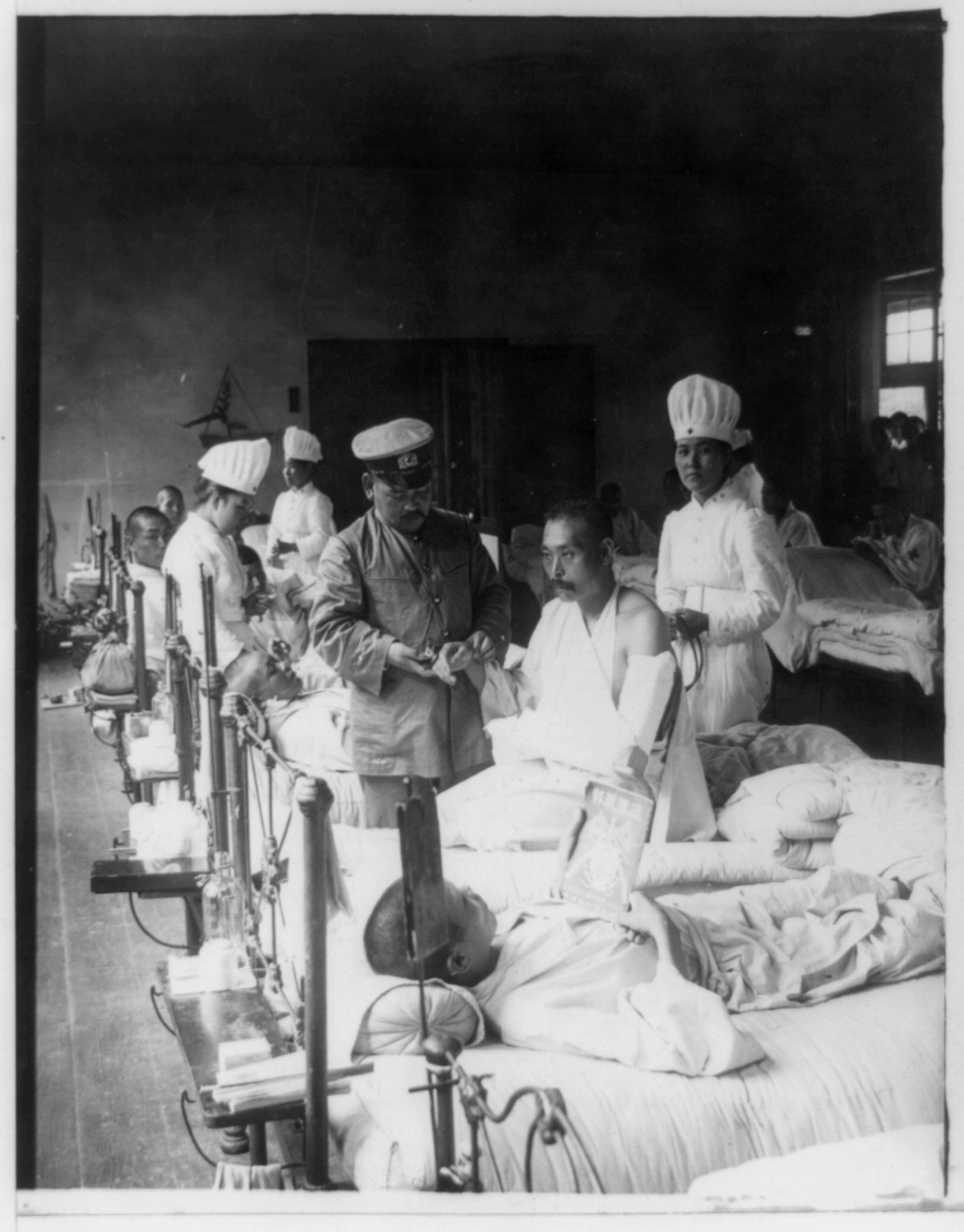 [Nurses and a doctor attending wounded soldiers on a hospital ward], New York, N.Y. : Underwood & Underwood, c1905. — historic photograph