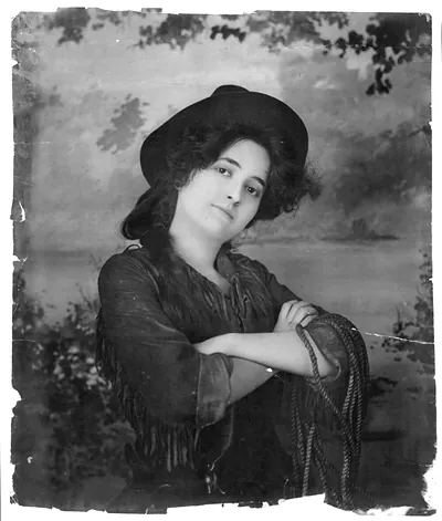 [Young woman modeling: Half lgth., wearing cowgirl outfit and holding rope]