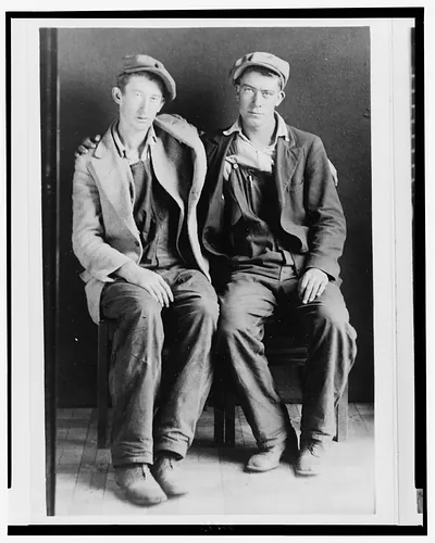 Southern Appalachian people, descendents of Europeans: 2 men in caps and overalls, full length, seated, with arms around each other