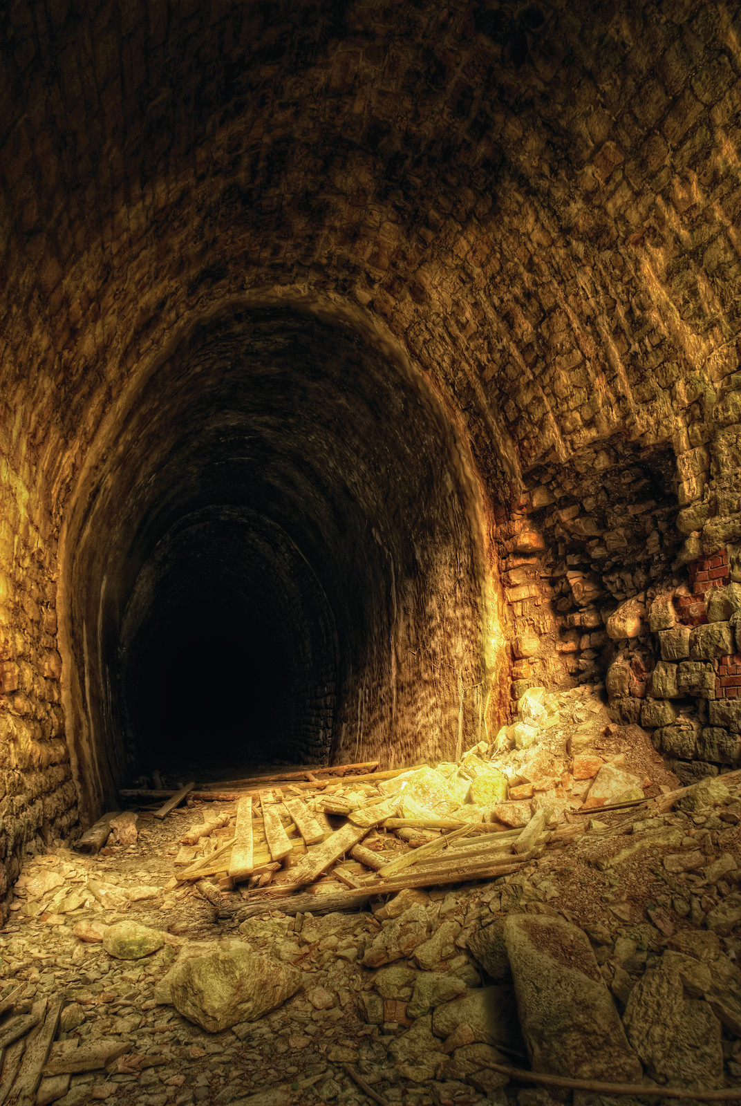Abandoned stone-arched tunnel with rubble and timber debris — historic image