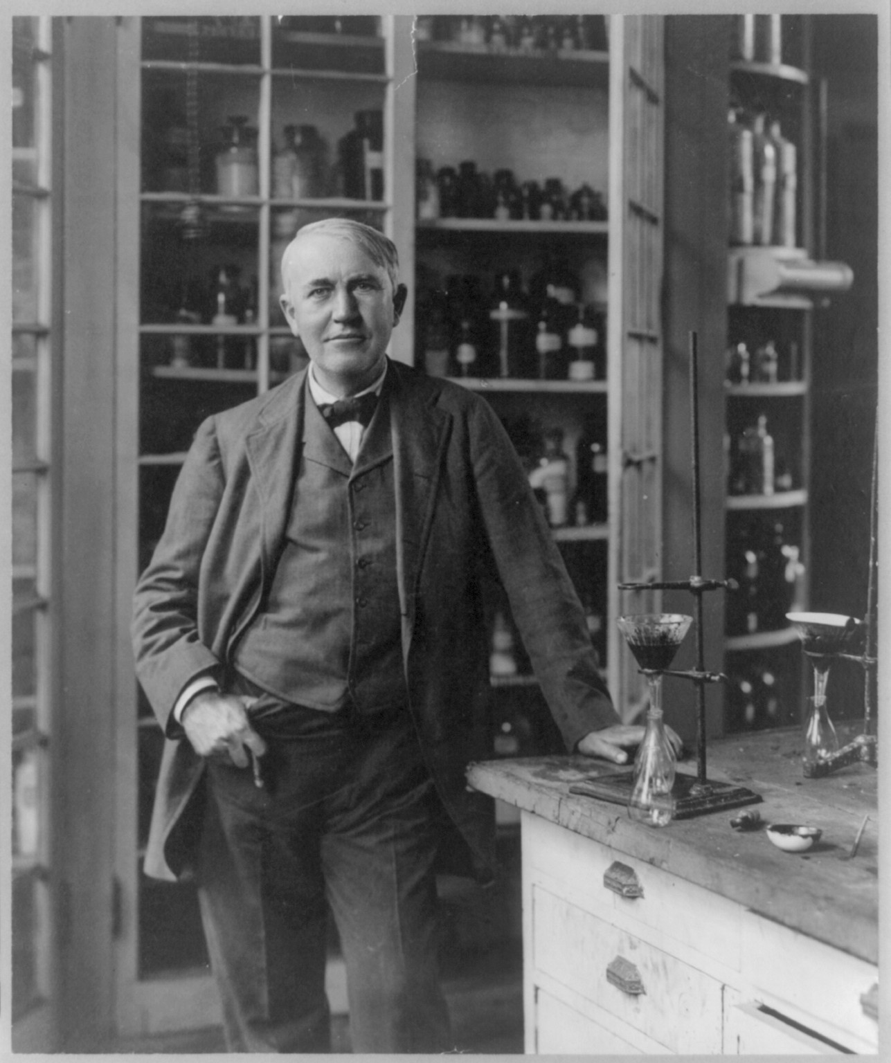 [Thomas Alva Edison, 1847-1931, three-quarter length portrait, standing, in laboratory], c1904. — historic photograph