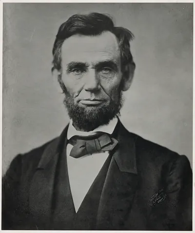 Photographic portrait of a bearded man in dark suit and bow tie