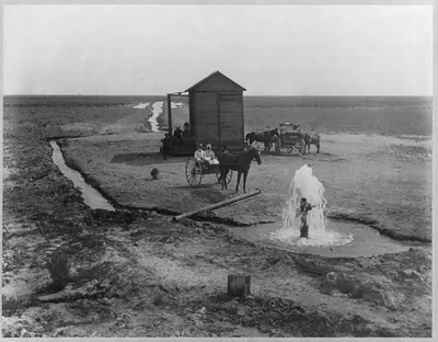 Horse-drawn cart beside artesian well