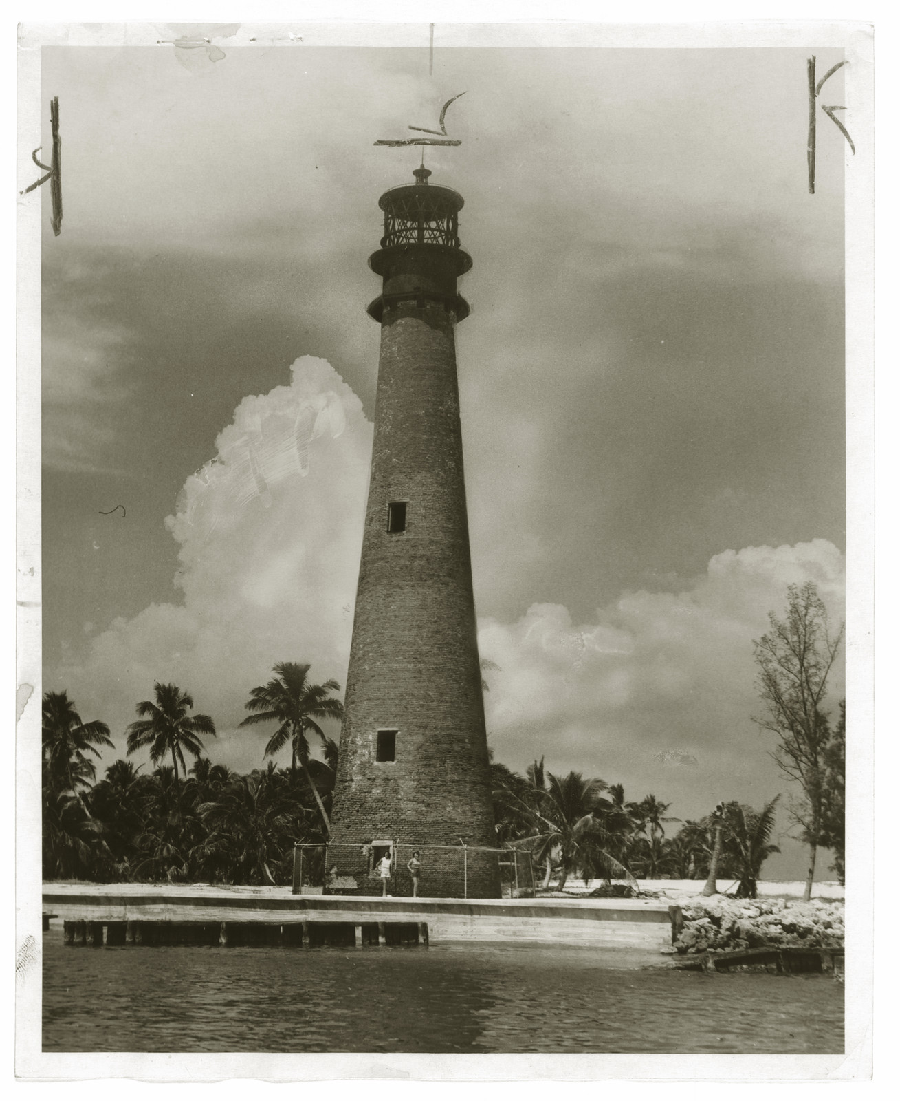 Brick lighthouse tower among palms, black-and-white photograph — historic photograph
