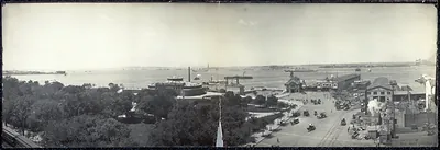 Panoramic view of New York harbor waterfront with horse carriages and automobiles