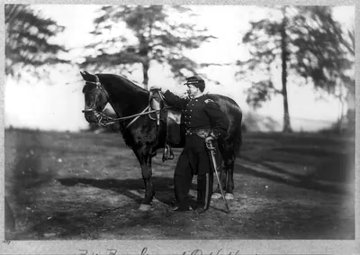[O.H. Hart, full-length portrait, standing, left profile, in uniform, alongside horse]