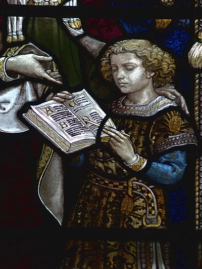 Stained glass detail of a boy with an alphabet book