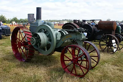 Vintage green tractor with red steel wheels at a show