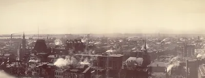 Panoramic view of Boston rooftops and chimney smoke