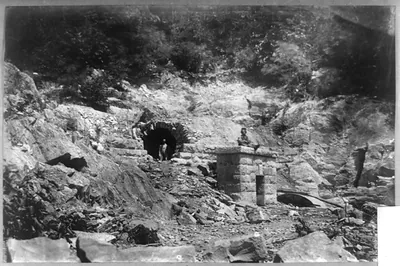 [Tunnel in rock, with three men]