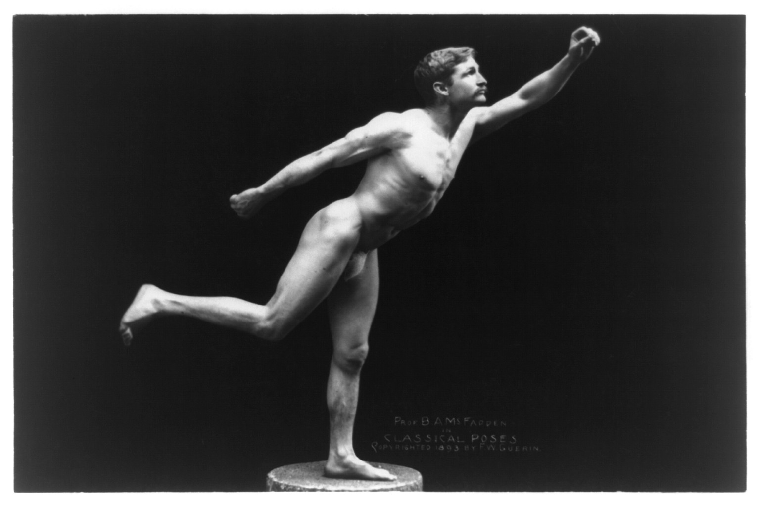 [Nude male, Prof. B.A. McFadden, full-length portrait, standing on one foot on pedestal, facing right, wearing a fig leaf], c1893. — historic photograph