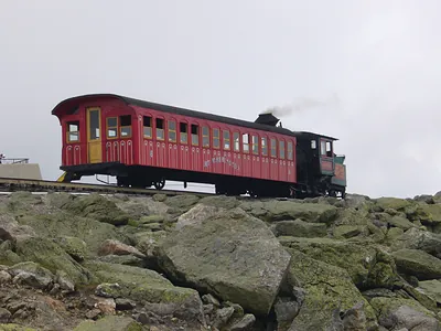 Red Mount Washington cog railway car on rocky mountainside