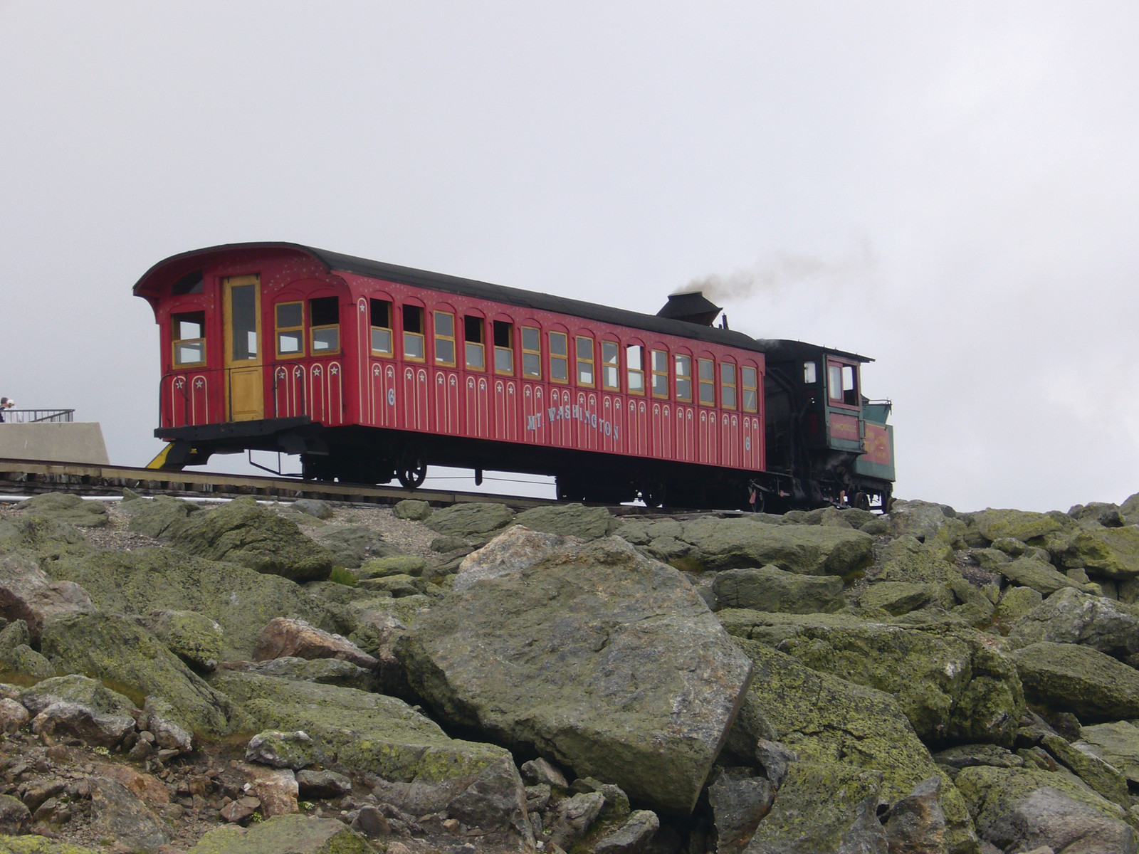 Red Mount Washington cog railway car on rocky mountainside — historic image