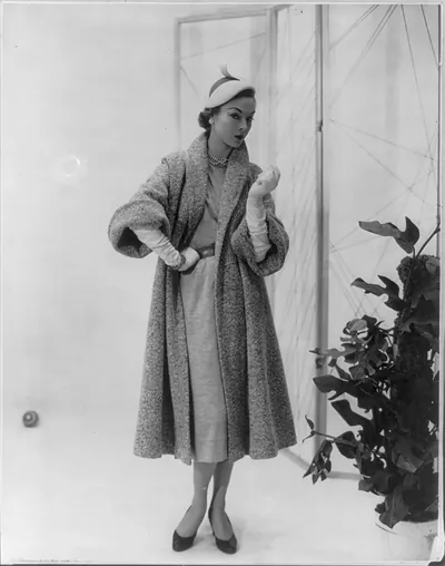 Women modeling fashions 1951-1952: Full coat in textured wool with the short sleeve popular in 1951