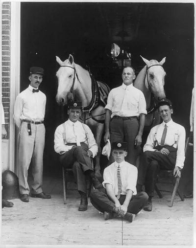 [5 firemen and 2 horses at dorway of firehouse, Webster Groves, Mo.]