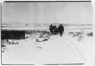 New York-to-Paris automobile race: [Man walking in front of automobile on snow-covered plains]