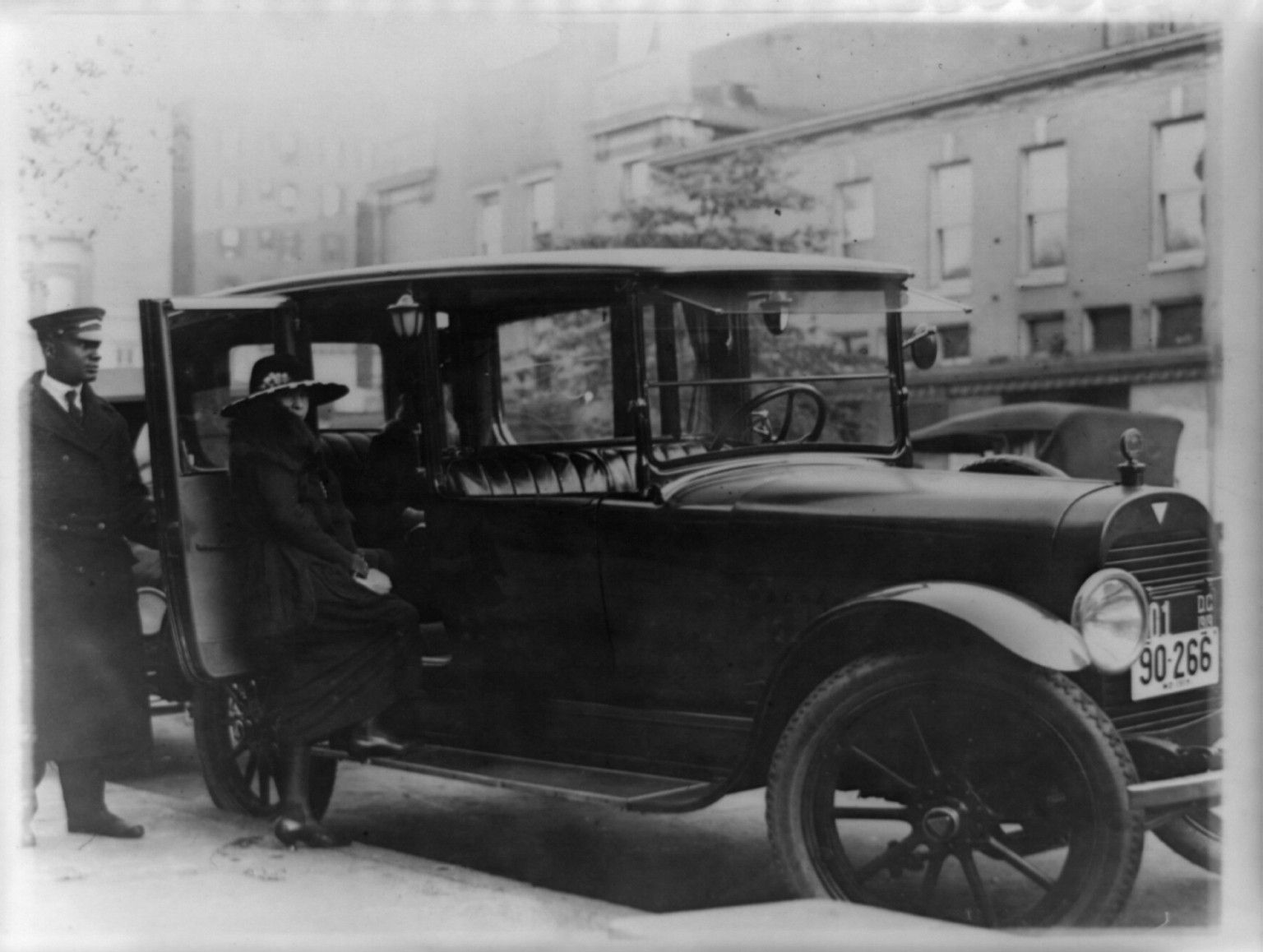 [Woman getting into back seat of car as chauffeur holds door, Washington, D.C., area], [1919] — historic photograph