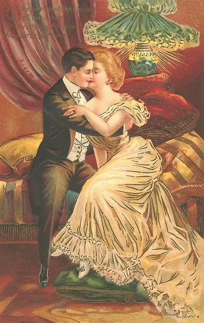 Romantic couple embracing on a sofa beneath a lamp