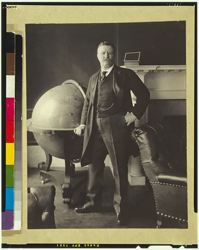 [Theodore Roosevelt, full-length portrait, standing beside large globe, facing front]