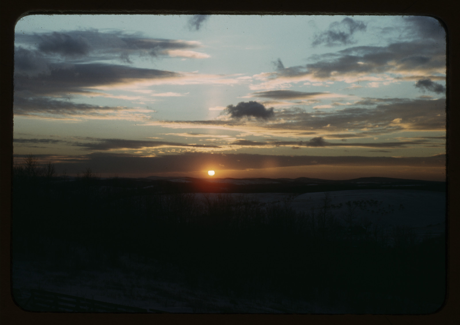 Sunset over dark horizon with scattered clouds — historic image