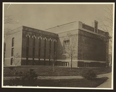 Brick building with vertical pilasters and lawn