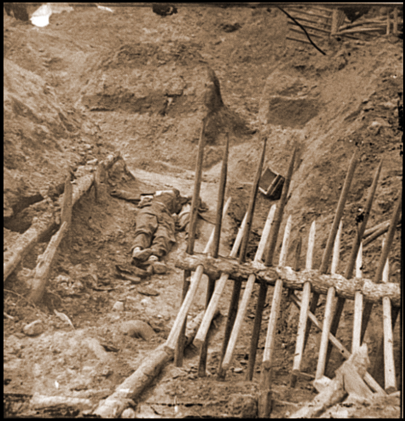 Petersburg Va. Dead Confederate soldier in trench beyond a section of chevaux-de-fr, 1865 — historic photograph