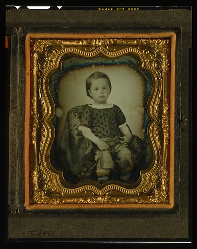 Seated young boy in gilt daguerreotype case, three-quarter view