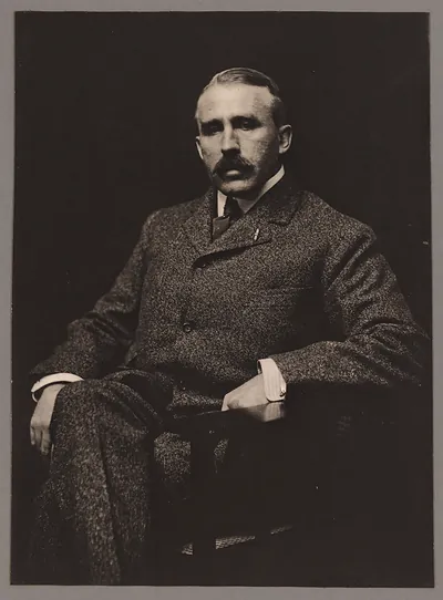 Seated man in tweed suit, studio portrait