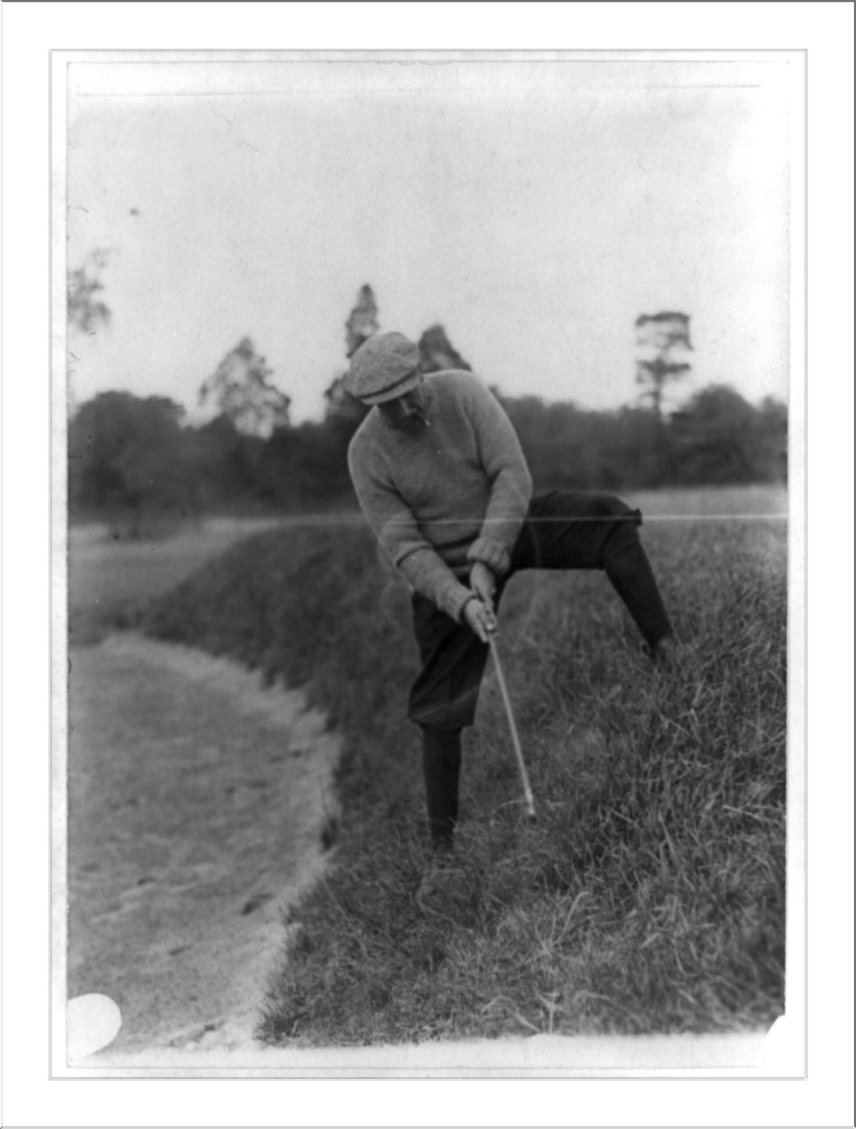 [Man swinging at golf ball up hill, Washington, D.C.], [between 1909 and 1932] — historic photograph