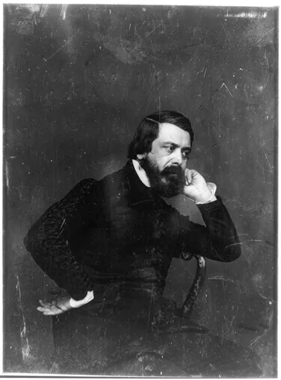 Seated bearded man in dark coat, three-quarter view
