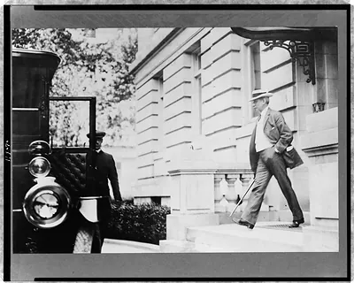 [Elihu Root, walking toward automobile and chauffeur]