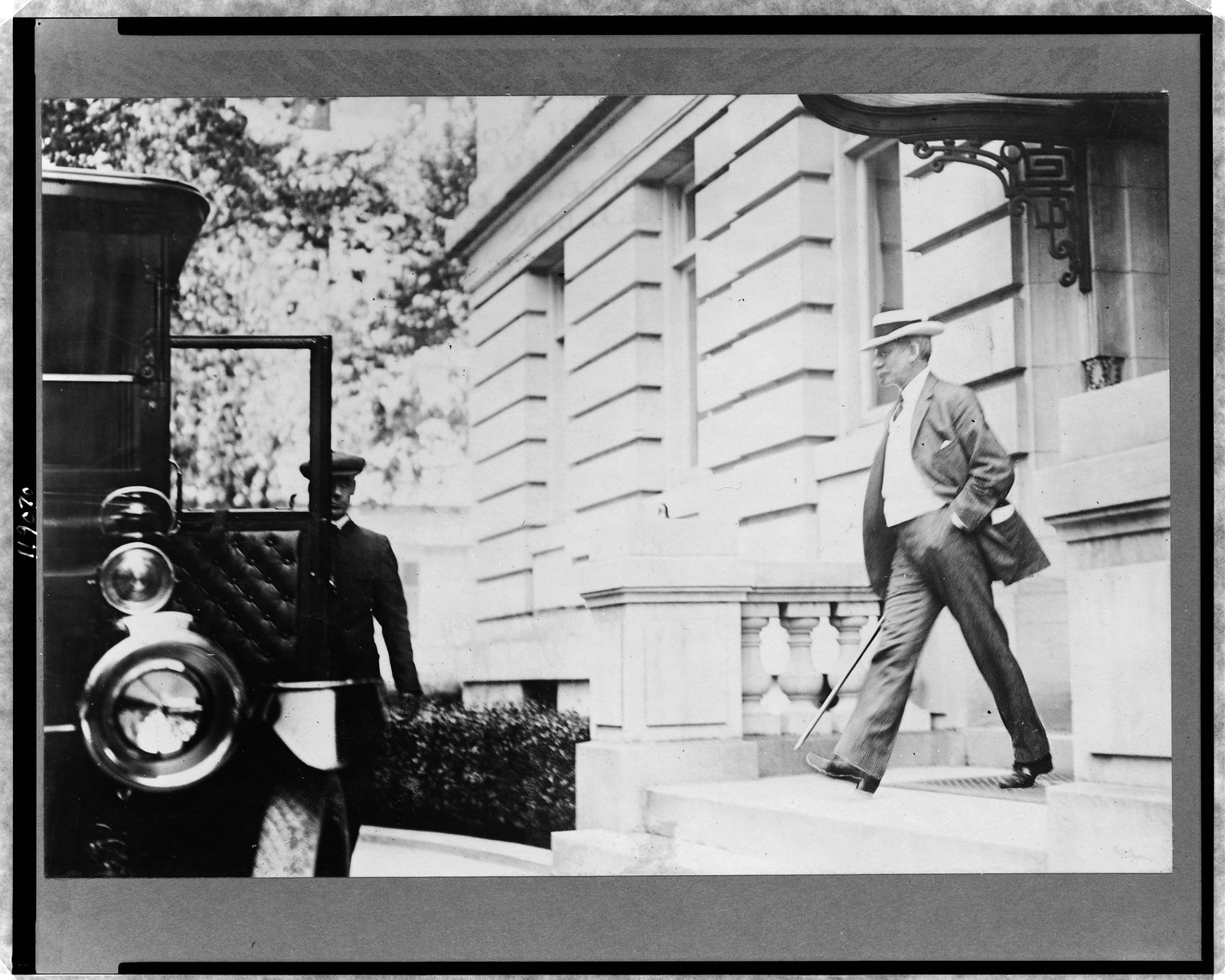 [Elihu Root, walking toward automobile and chauffeur], c1912. — historic photograph