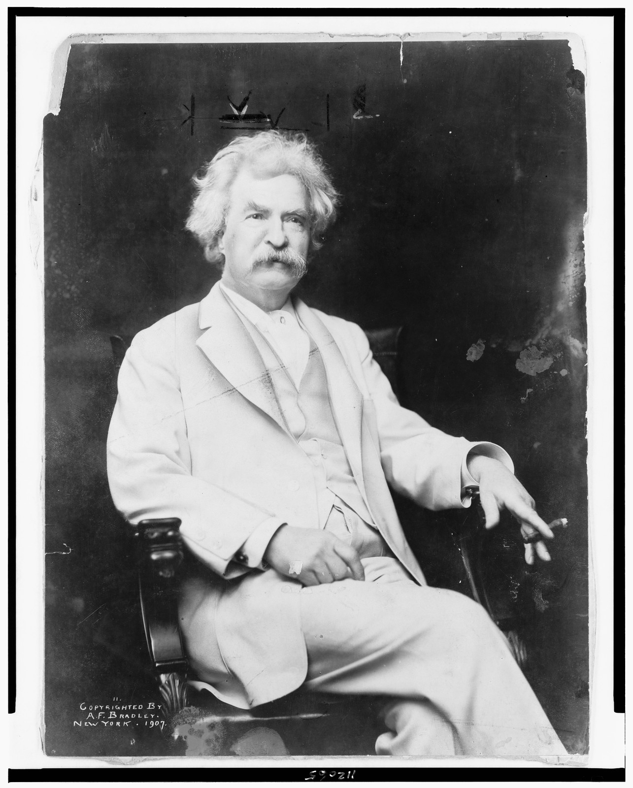 [Mark Twain, three-quarter length portrait, seated, facing slightly right, with cigar in hand], c1907. — historic photograph