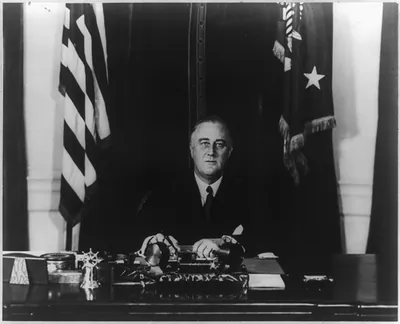 [Franklin D. Roosevelt, head and shoulders, seated at desk, facing front]