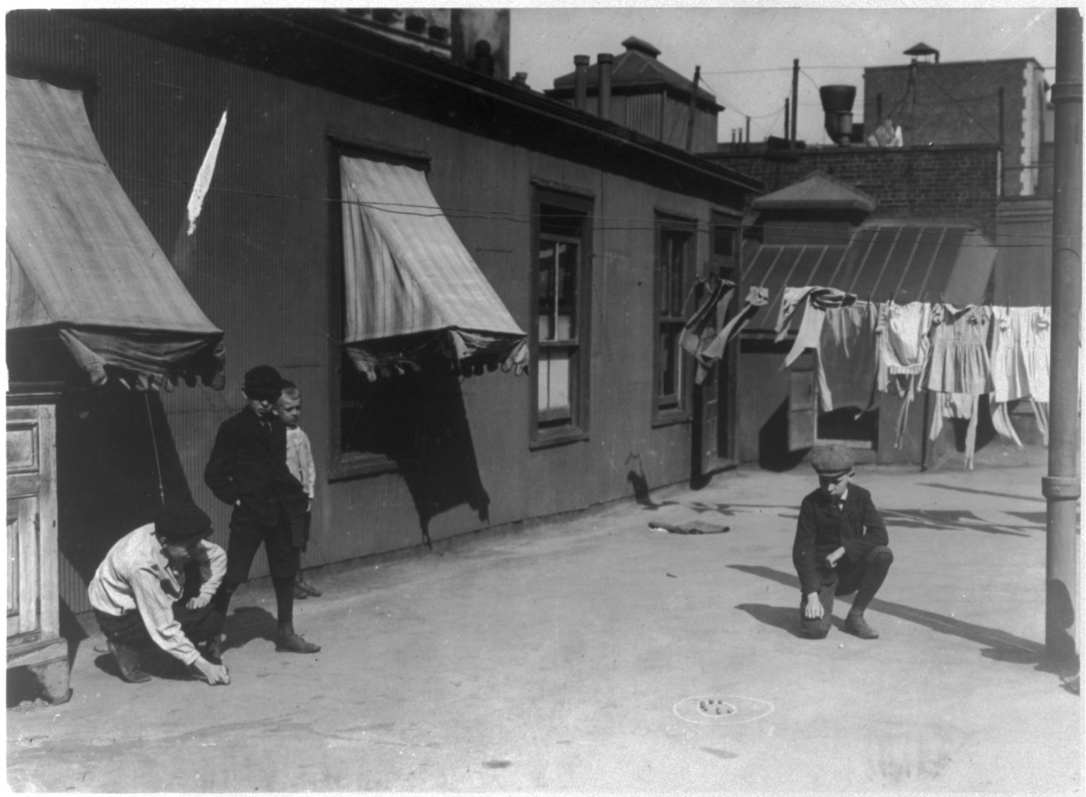 [New York City - children on the street: hot weather street scene - Boys shooting marbles], [between 1908 and 1915] — historic photograph
