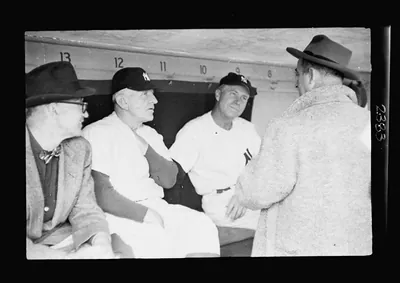 [New York Yankee manager Casey Stengle and player Mickey Mantle in dugout with two other men] / Kenneth Eide.