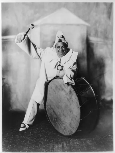 [Enrico Caruso, 1873-1921, dressed as clown, beating bass drum, in Pagliaci"]"