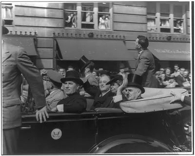 [Franklin Delano Roosevelt, in open car, waving top hat, with Mrs. FDR, Sen. Joseph F. Guffey, and Demo. city chairman John B. Kelly. Philadelphia, Sept. 20, 1940, facing left]