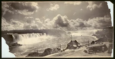 Niagara Falls with cloud-filled sky and a riverside pavilion
