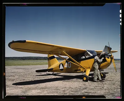 Civil Air Patrol yellow monoplane with pilot on airfield