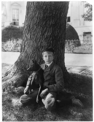 [Kermit Roosevelt seated under tree holding his dog Jack]