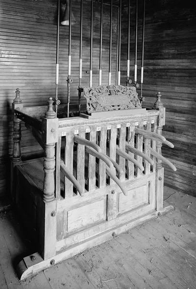 Wooden pipe organ keyboard with carved nameplate and stop rods