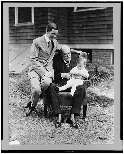 [Charles Evans Hughes, seated, full-length, holding his grandson, with Charles Evans Hughes, Jr. seated on arm of the same chair]