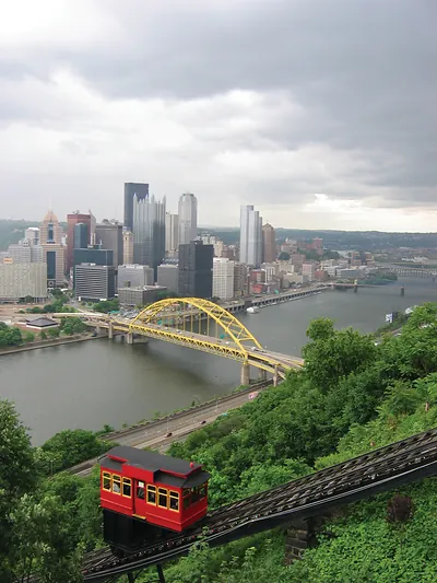 Red Duquesne Incline car overlooking downtown Pittsburgh skyline