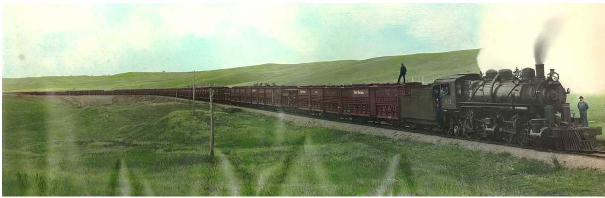 Hand-colored photograph of steam locomotive hauling freight train — historic photograph