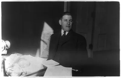 [Thomas W. Brahany, 1876-1964, half-length portrait, seated at desk, facing right]