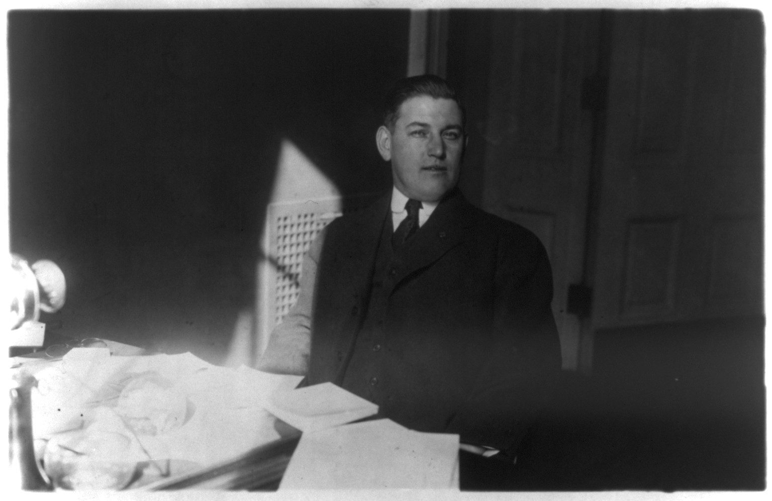 [Thomas W. Brahany, 1876-1964, half-length portrait, seated at desk, facing right] — historic photograph