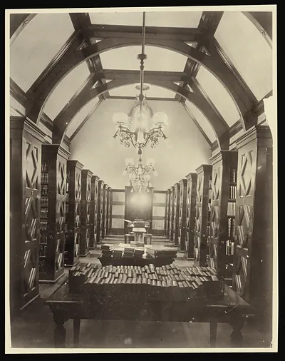 Library bookroom with vaulted ceiling, tall shelves and chandelier